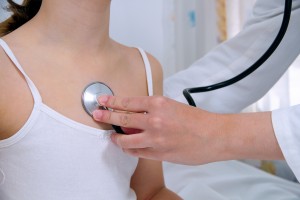 Femele doctor examining little girl with stethoscope